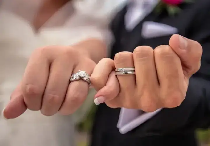 Engagement rings on a couple's linked hands