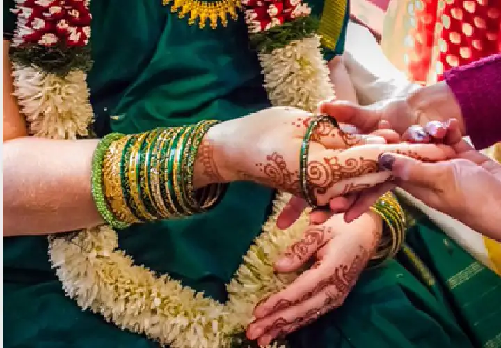 Seemantham ceremony with green bangles, henna and flower garlands
