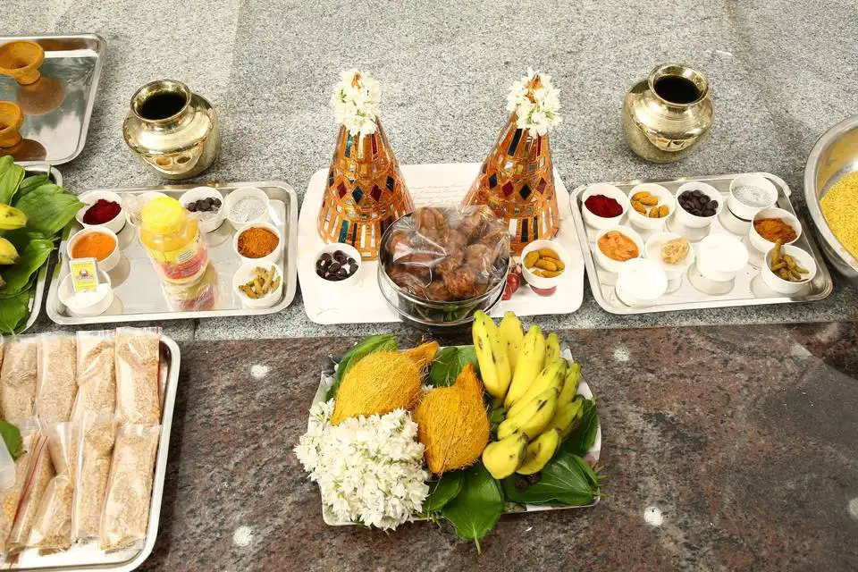 Traditional South Indian ceremonial setup with brass vessels, fruits and flowers